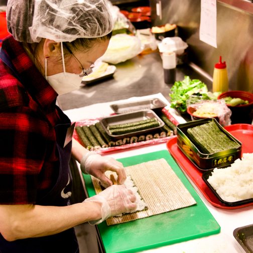 Uwajimaya | Deli Employee Rolling Sushi