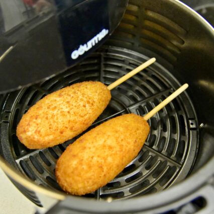 Two Pulmuone Mozzarella Cheddar Fishcakes in an Air Fryer Basket